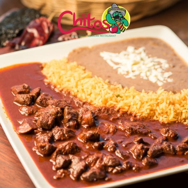 Chitos Mexican Restaurant's chile colorado with rice and refried beans, garnished with cheese.